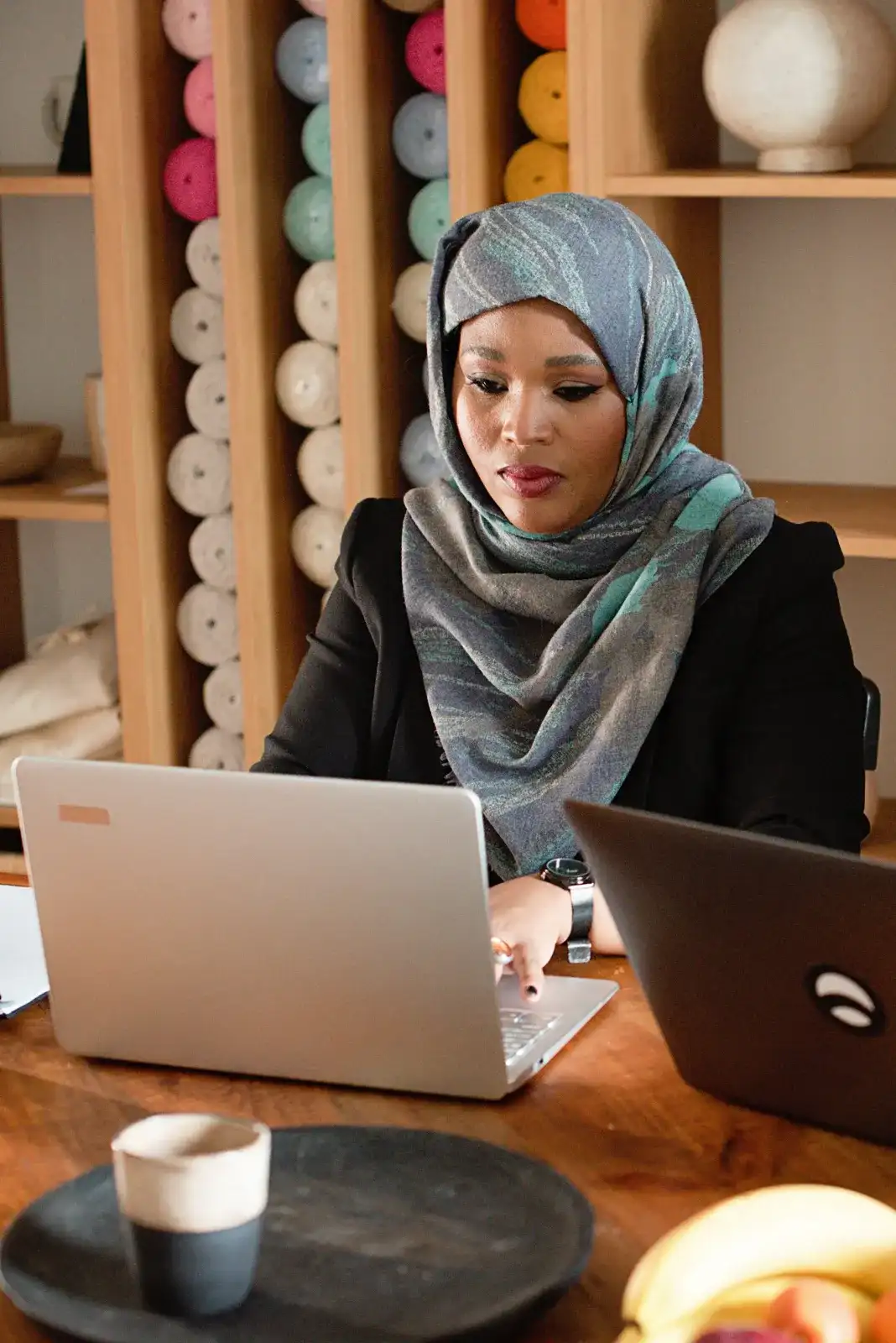 A founder in a hijab working on a laptop