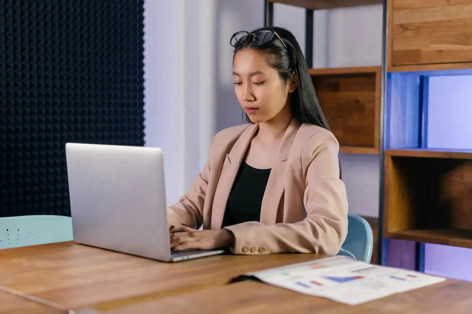 A founder working on a laptop at a wooden desk