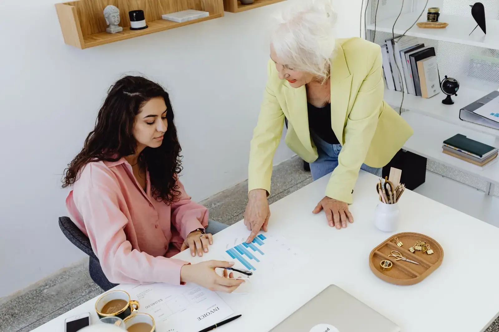 Two women reviewing charts at a desk